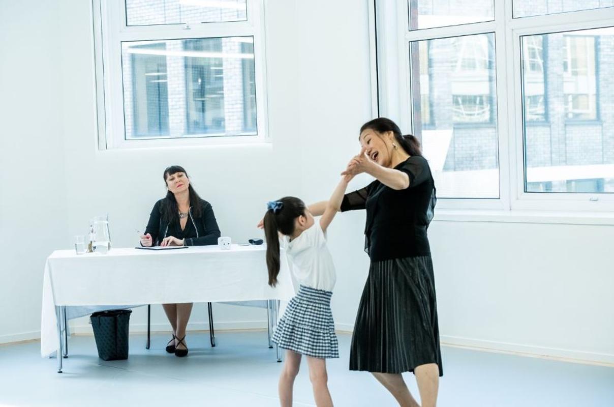 Child student with adult teacher in examination setting