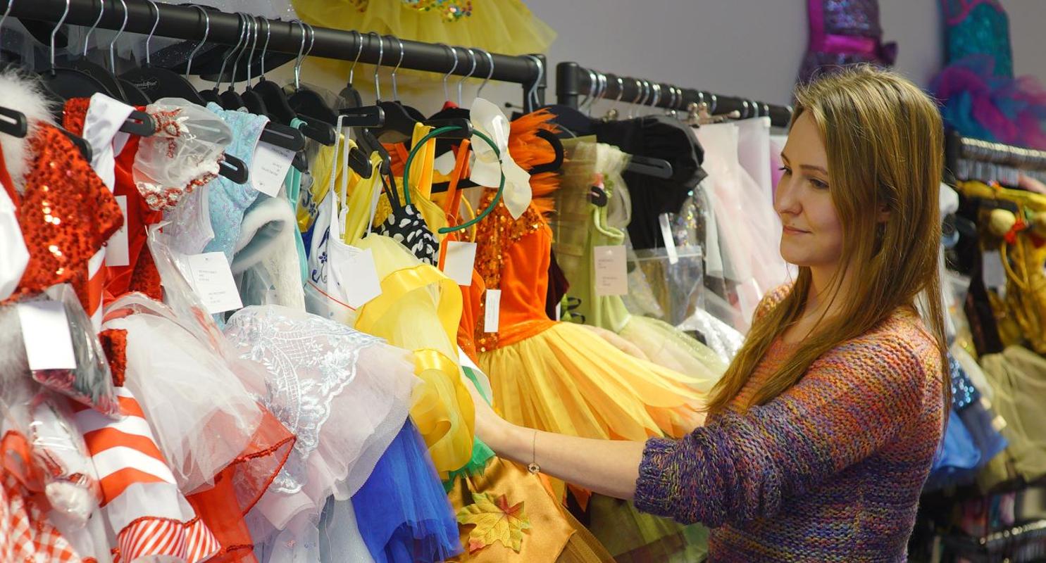 Lady looking at International Dance Supplies costumes on a rail