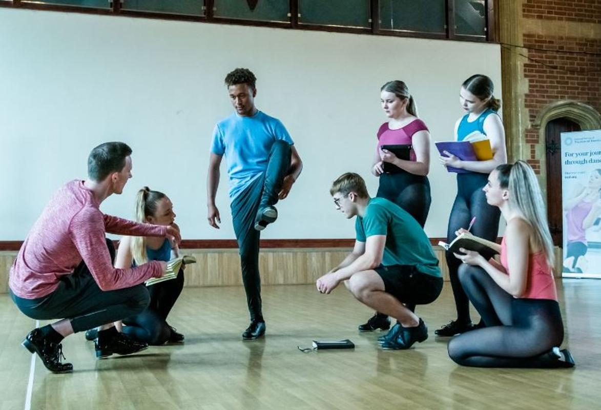 Dancer showing dance shoes to dance teacher and students