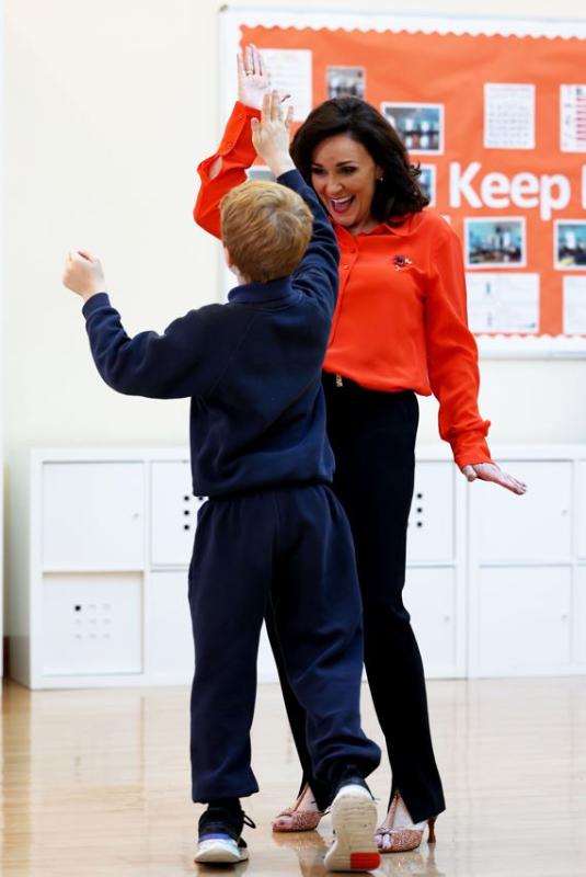 Shirley Ballas high fiving a a student 