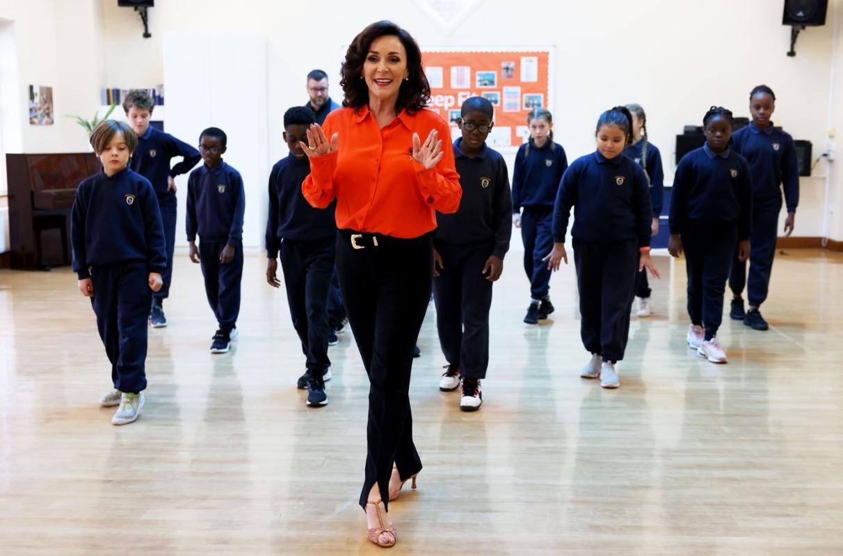 Shirley at school with students teaching them how to dance