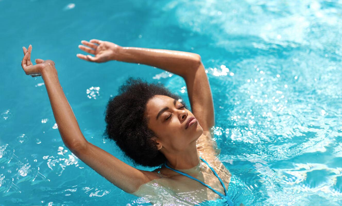 Woman swimming in pool for her wellbeing