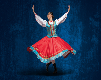 A young, white female dancer demonstrates a national dance move