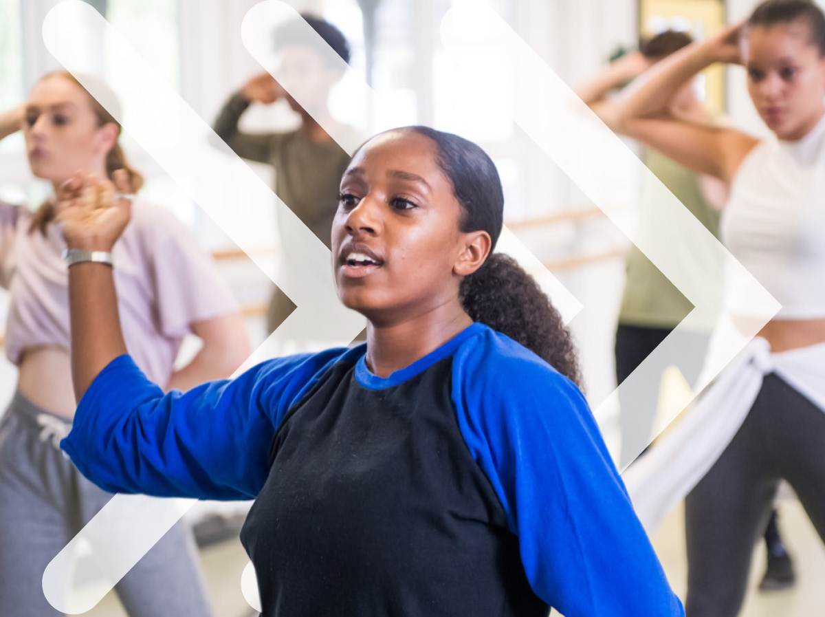 A student mid-dance stop, with ISTD chevrons in the background