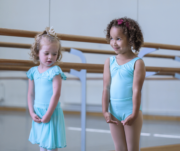 two little dancers wearing green uniform